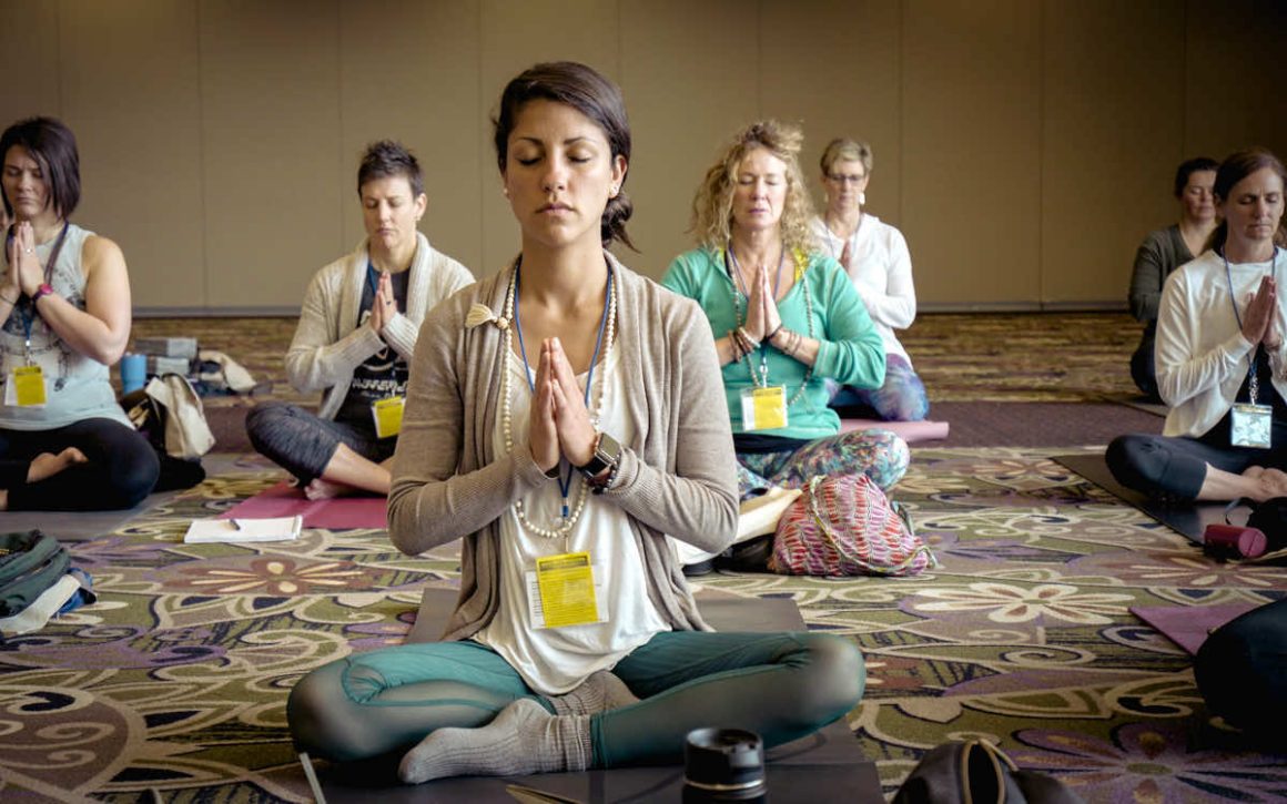 Women doing a seated yoga pose.