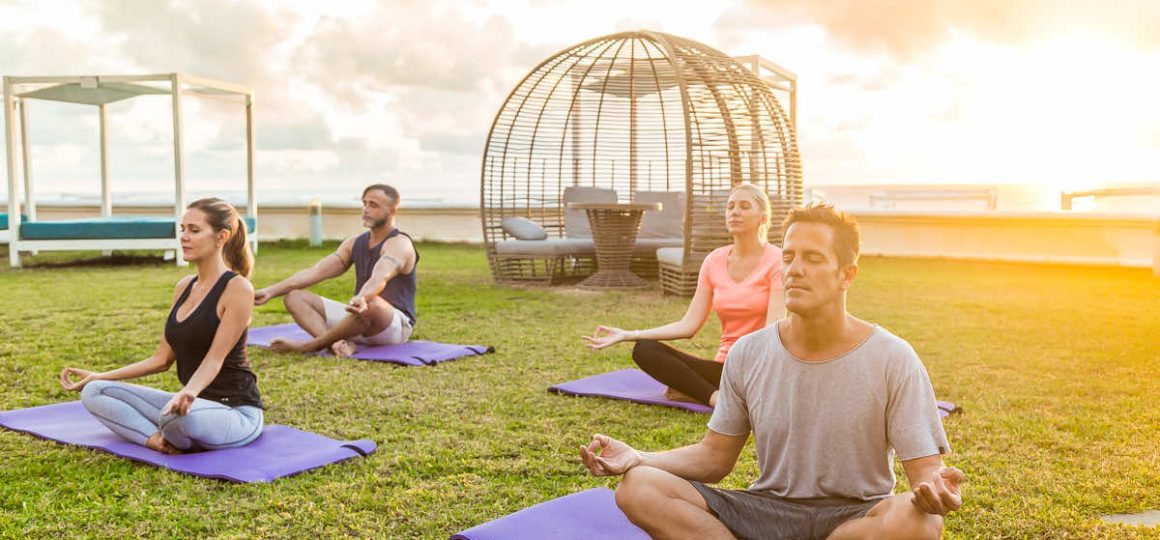 People seated in the park meditating.